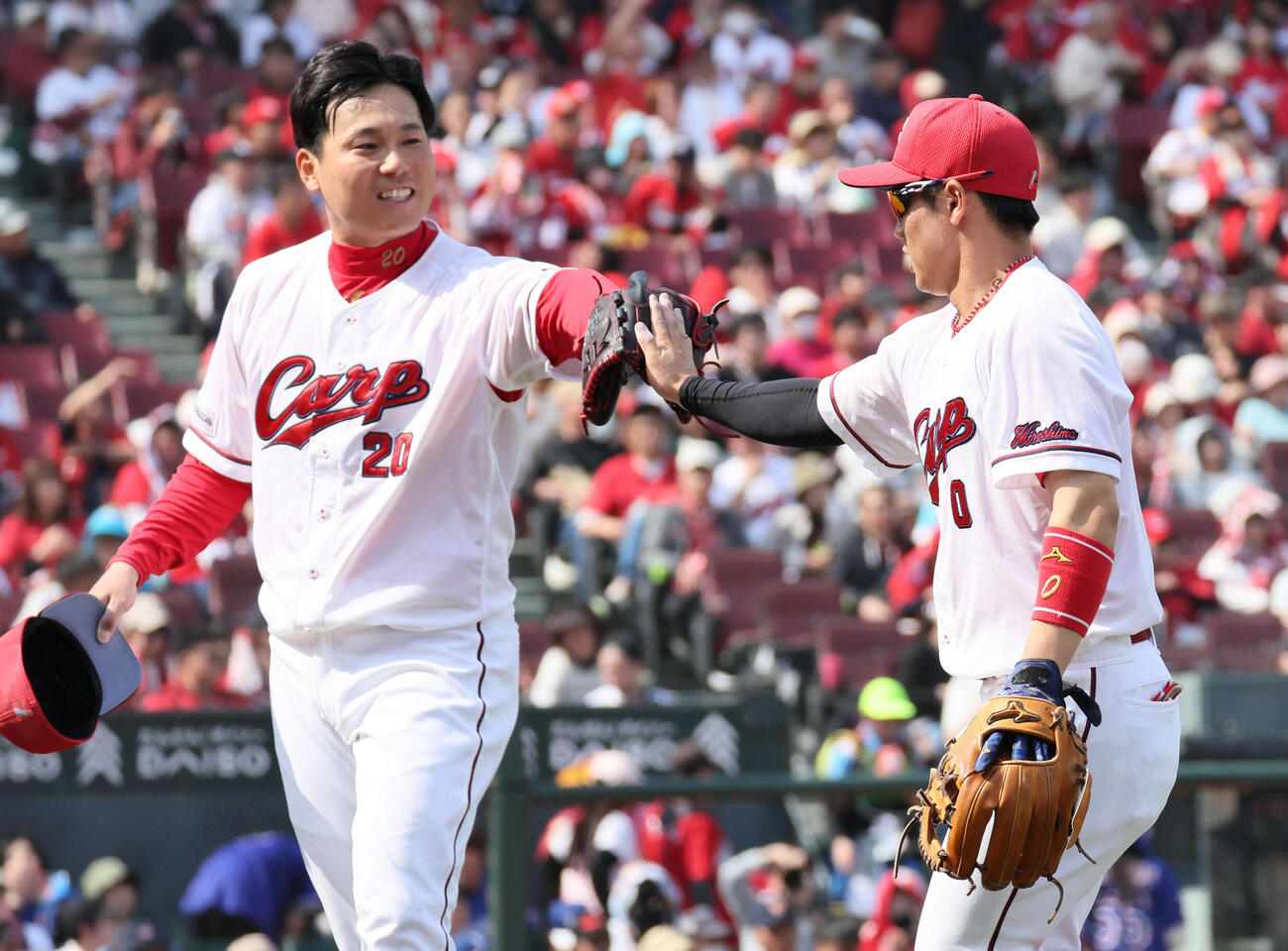 広島対中日　5回表終了時、好守の勝田を迎える先発の栗林（左）（撮影・加藤孝規）