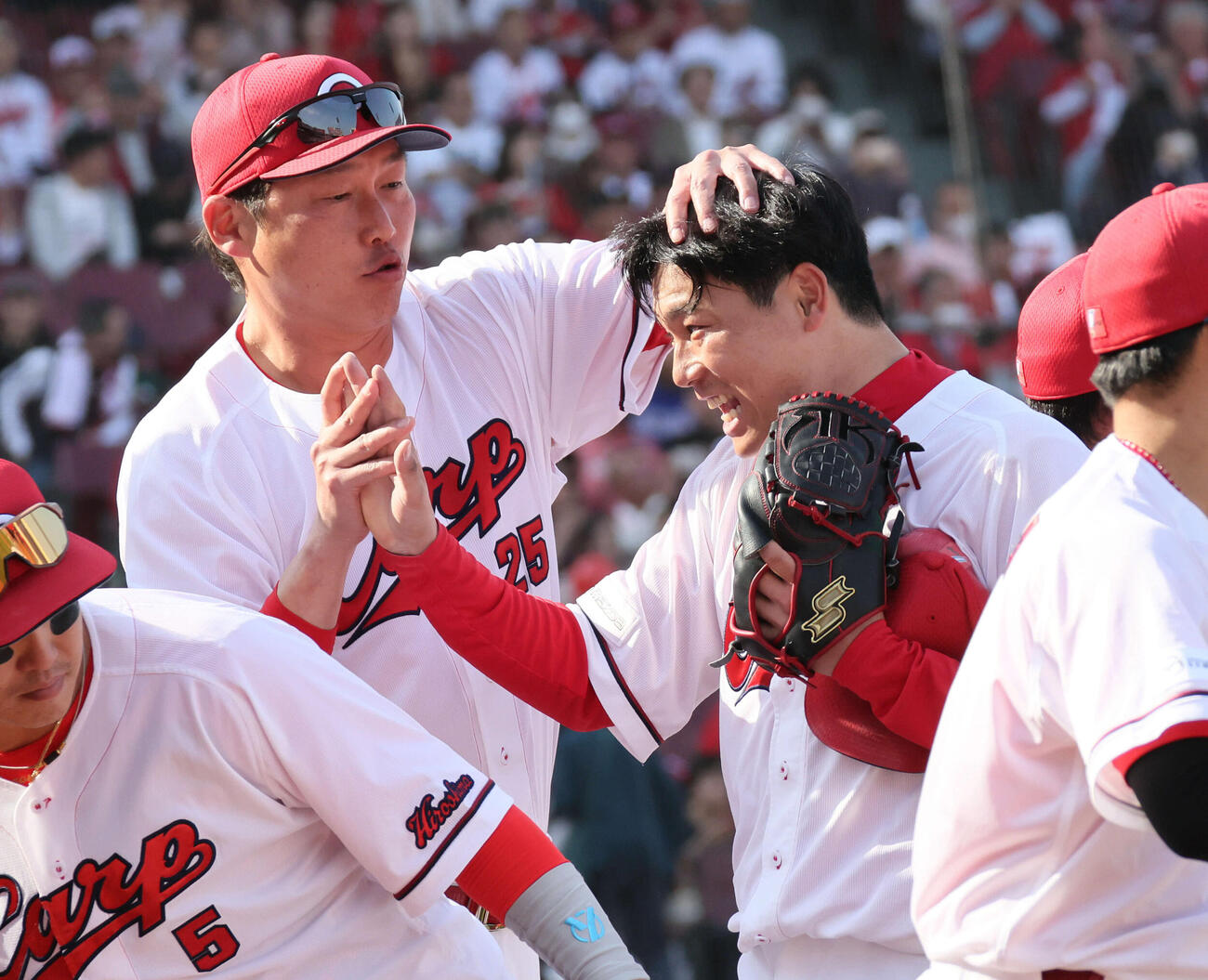 広島対中日　新井監督（左）に迎えられるマダックス1安打完封勝利を決めた栗林（撮影・加藤孝規）