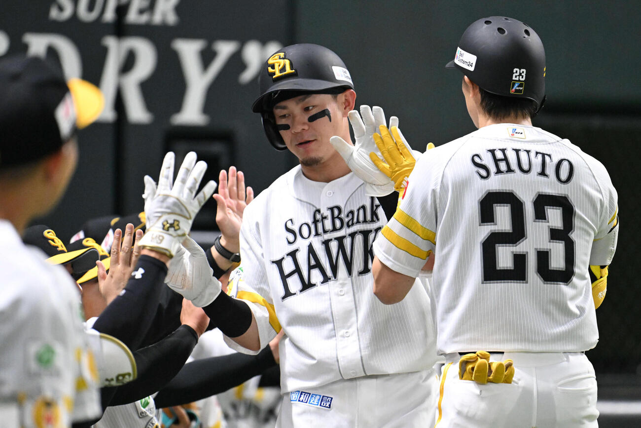 ソフトバンク対日本ハム　2回裏ソフトバンク1死二、三塁、生還した牧原大（中央）はナインとタッチを交わす（撮影・林敢治）