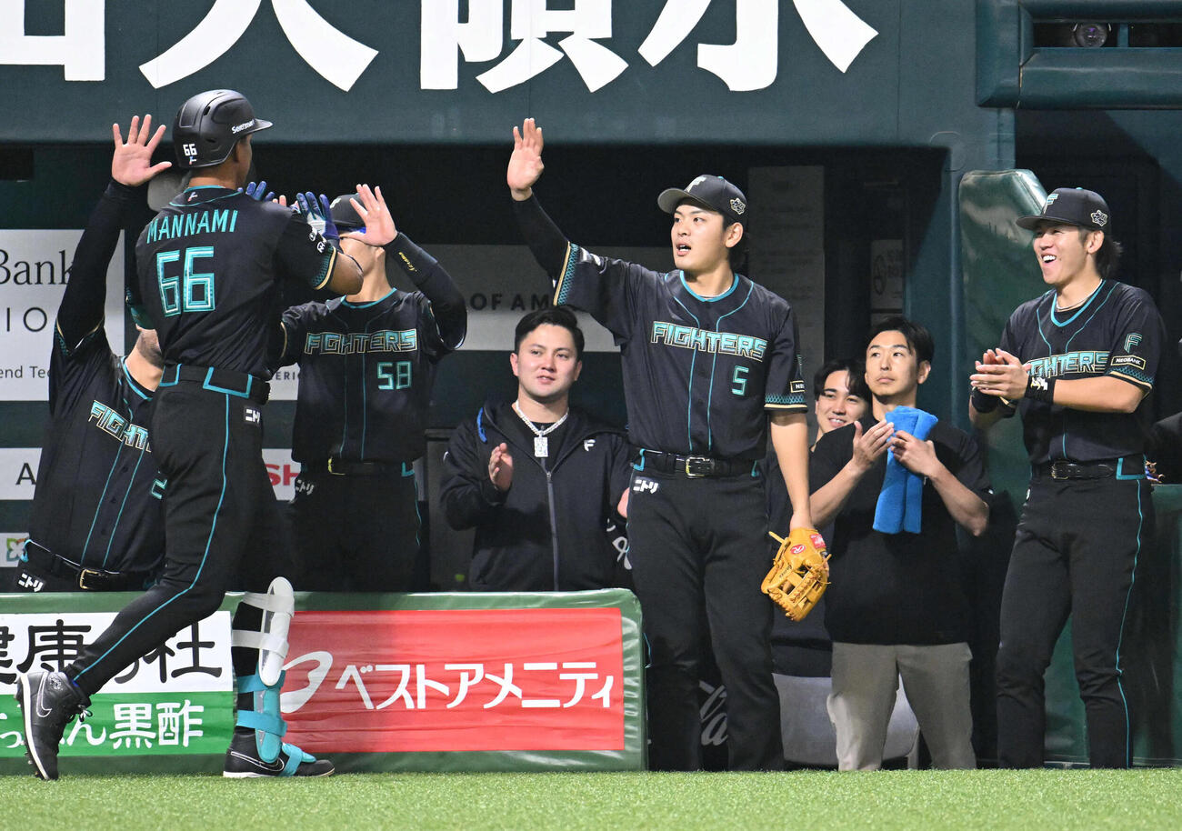 ソフトバンク対日本ハム　2回表日本ハム1死、万波（左）は本塁打を放ちナインとタッチを交わす（撮影・林敢治）