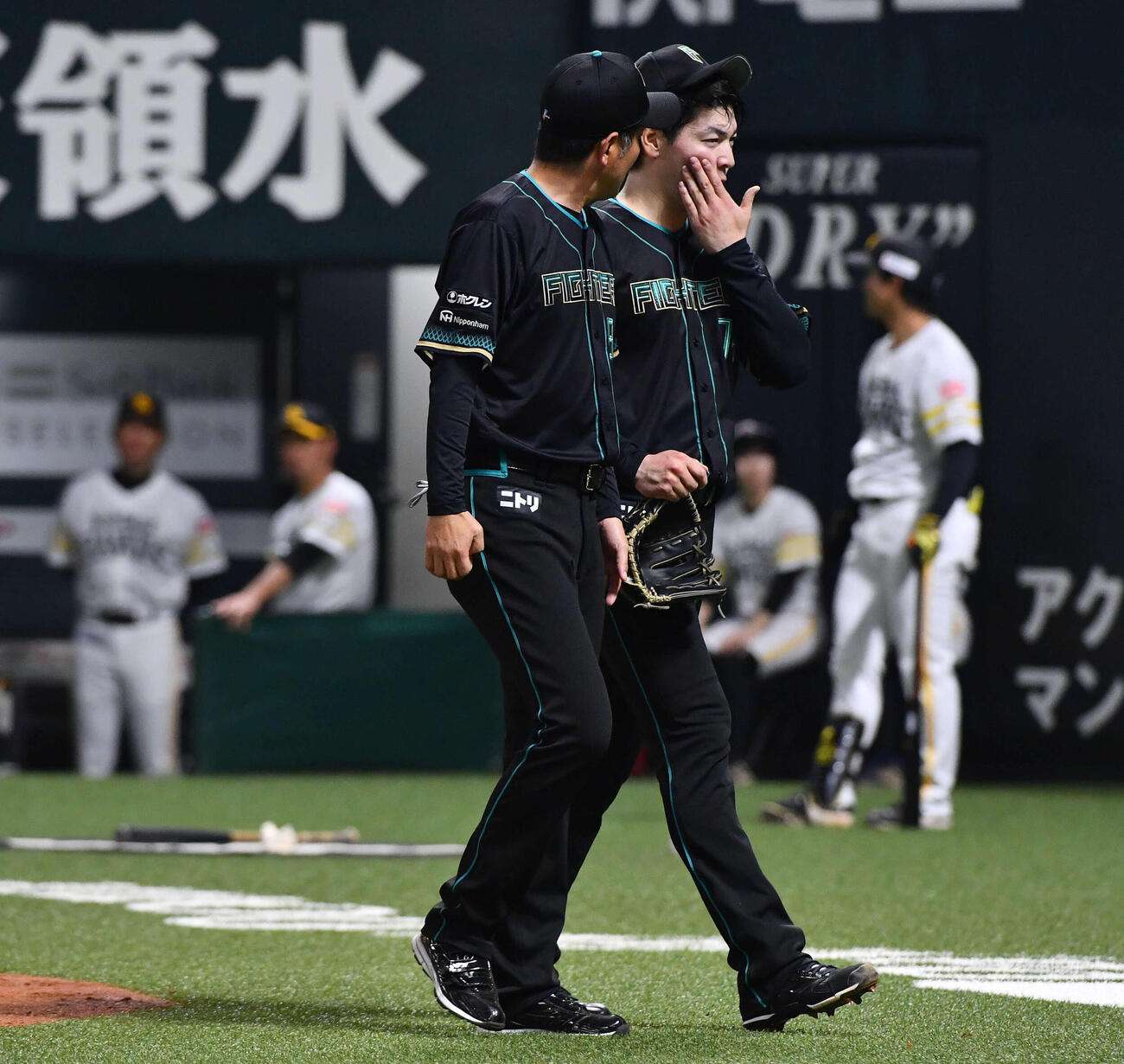 ソフトバンク対日本ハム　2回裏ソフトバンク2死三塁、暴投で生還した三塁走者の川瀬を避けた際に捕手の田宮と交錯し、手当てを受けるためベンチへ戻る有原（撮影・岩下翔太）
