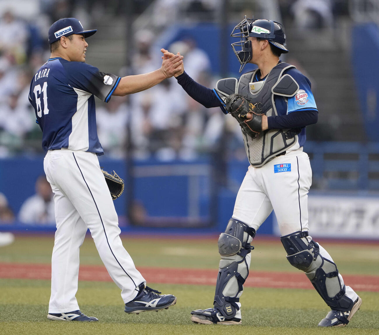 ロッテに完封勝利しハイタッチする西武平良（左）と小島（撮影・小島史椰）