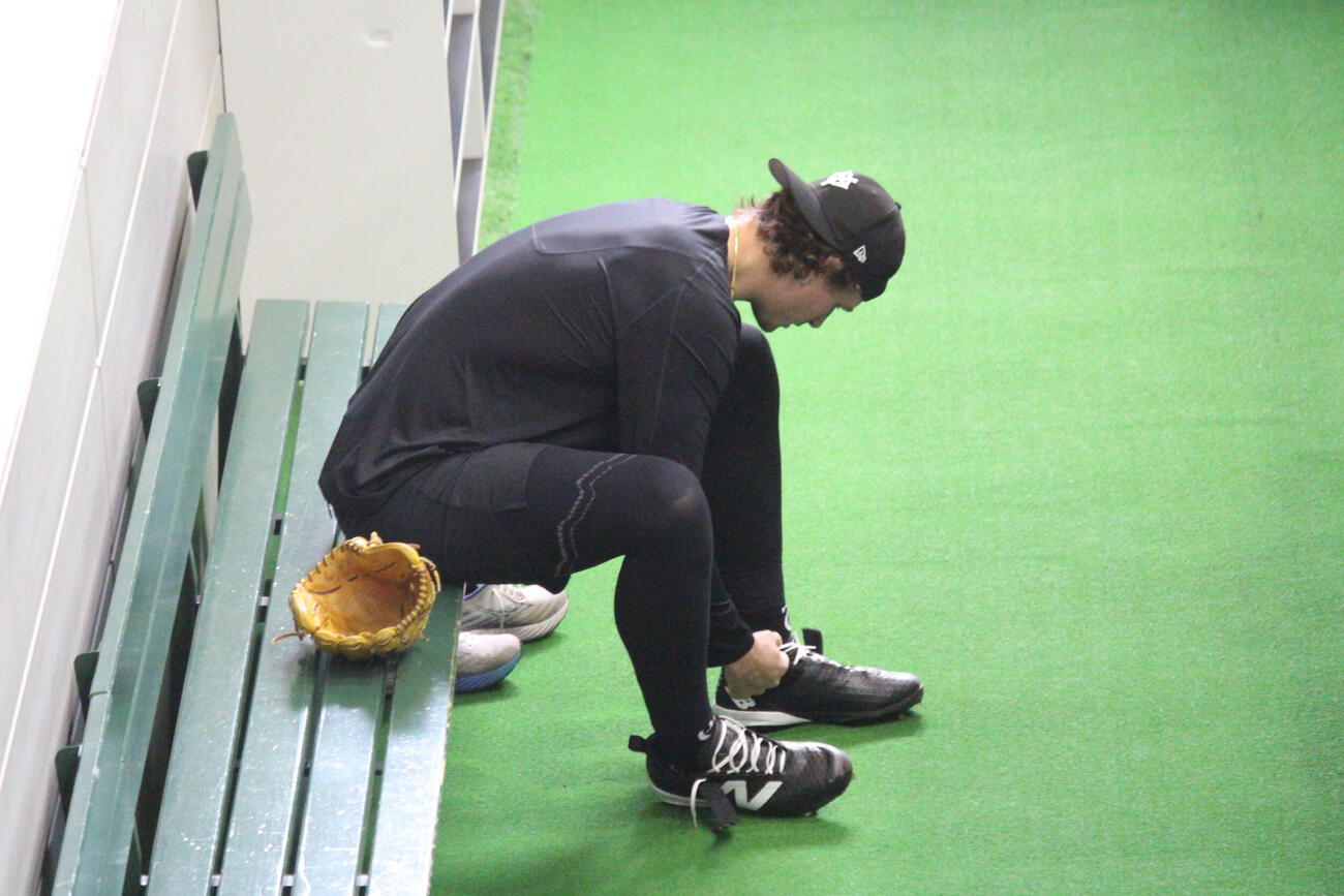 ウィットリーは練習前に靴ひもを結んで準備を進める