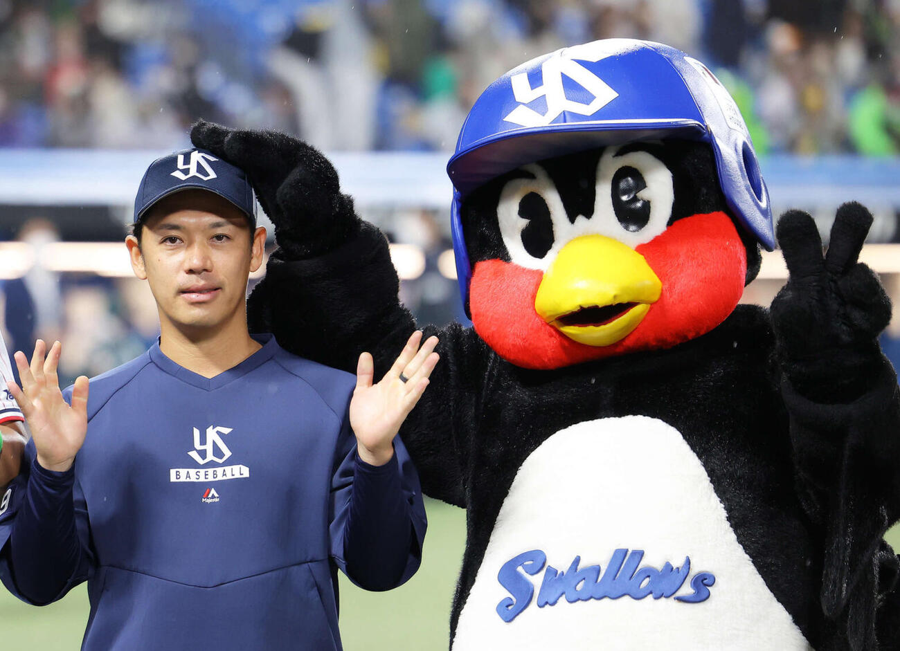 つば九郎に頭をなでられる小川泰弘（2022年10月撮影）