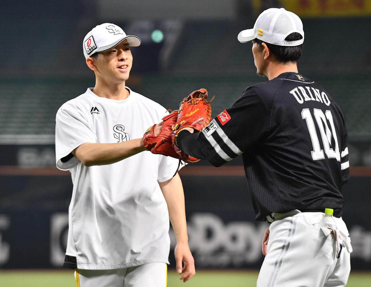 瓜野ブルペン捕手（右）とのキャッチボールを終えてグラブタッチを交わすソフトバンク大関（撮影・岩下翔太）