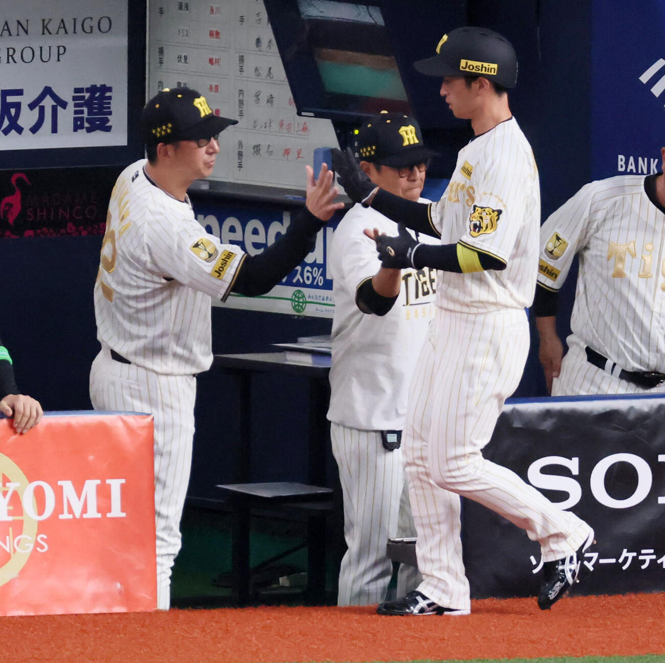 阪神対DeNA 1回裏阪神2死二塁、佐藤の右越え先制適時二塁打で生還し藤川監督（左）とタッチする二走近本（撮影・加藤哉）