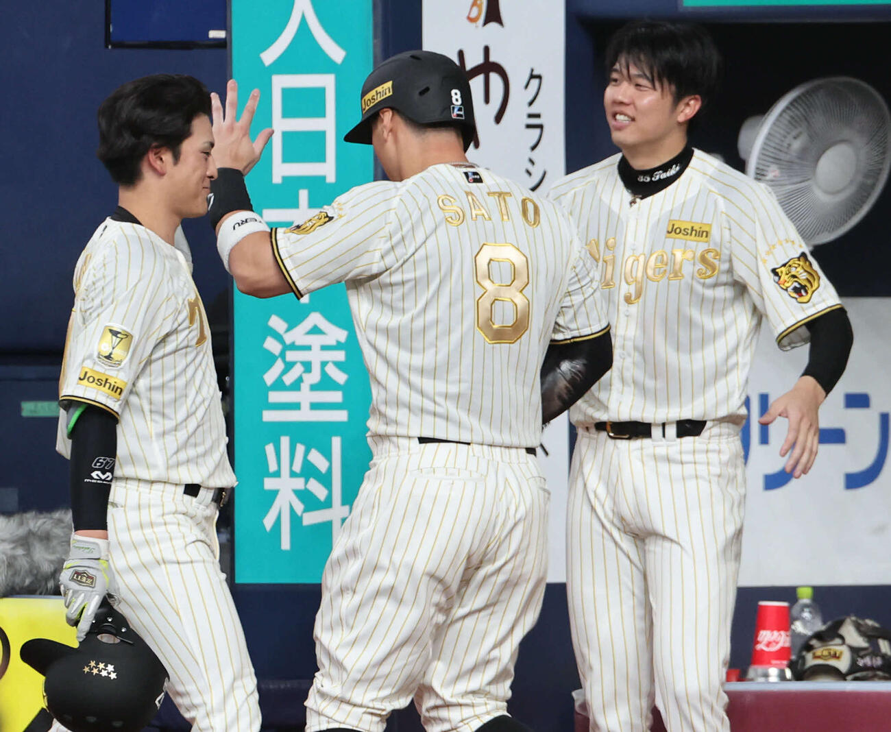 阪神対DeNA 6回裏阪神無死二、三塁、犠飛の高寺（左）生還した佐藤（中）を迎える阪神才木（撮影・西尾就之）