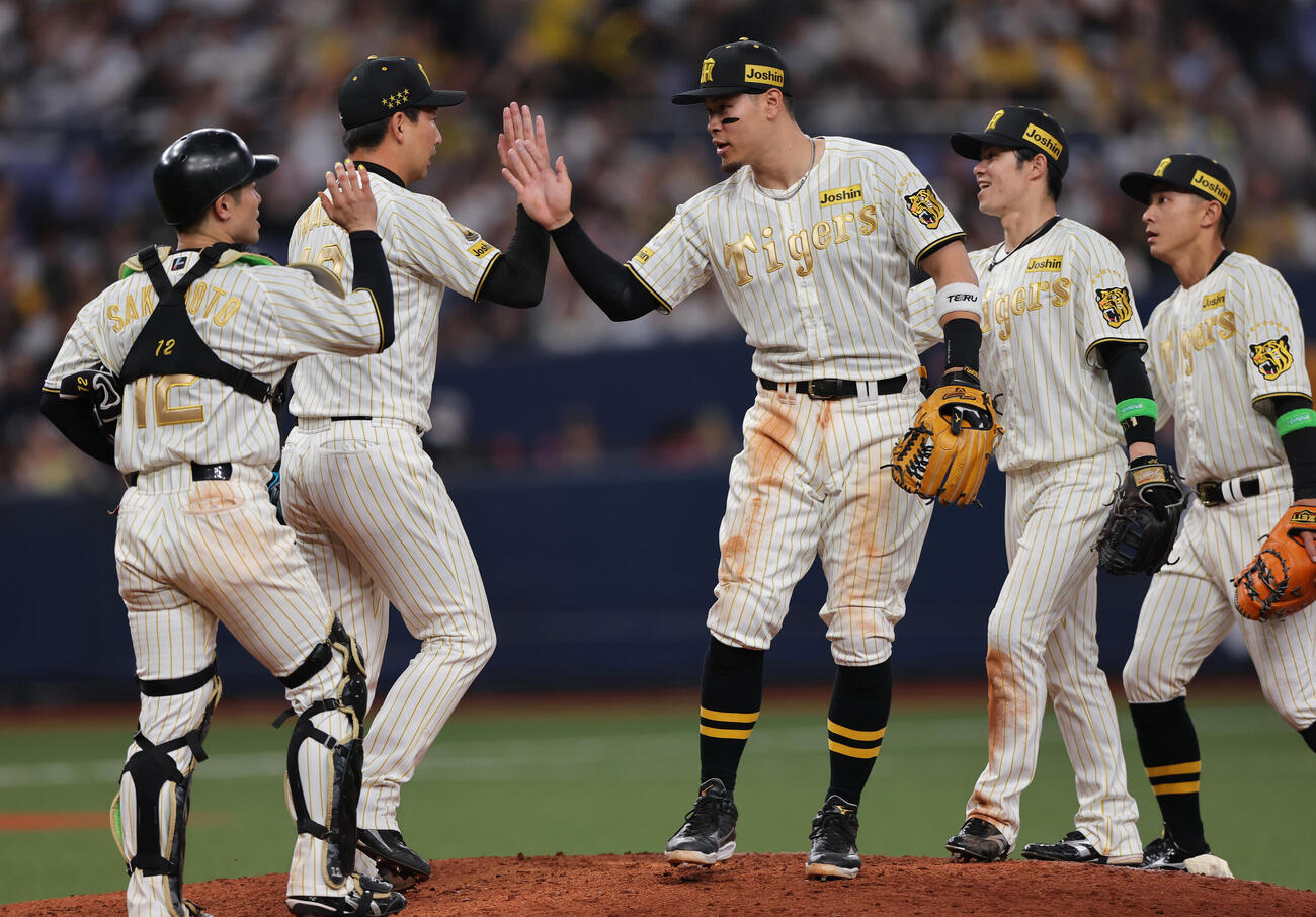 阪神対DeNA DeNAに勝利し、試合を締めた岩崎（左から2人目）はナインとタッチをかわす（撮影・上山淳一）
