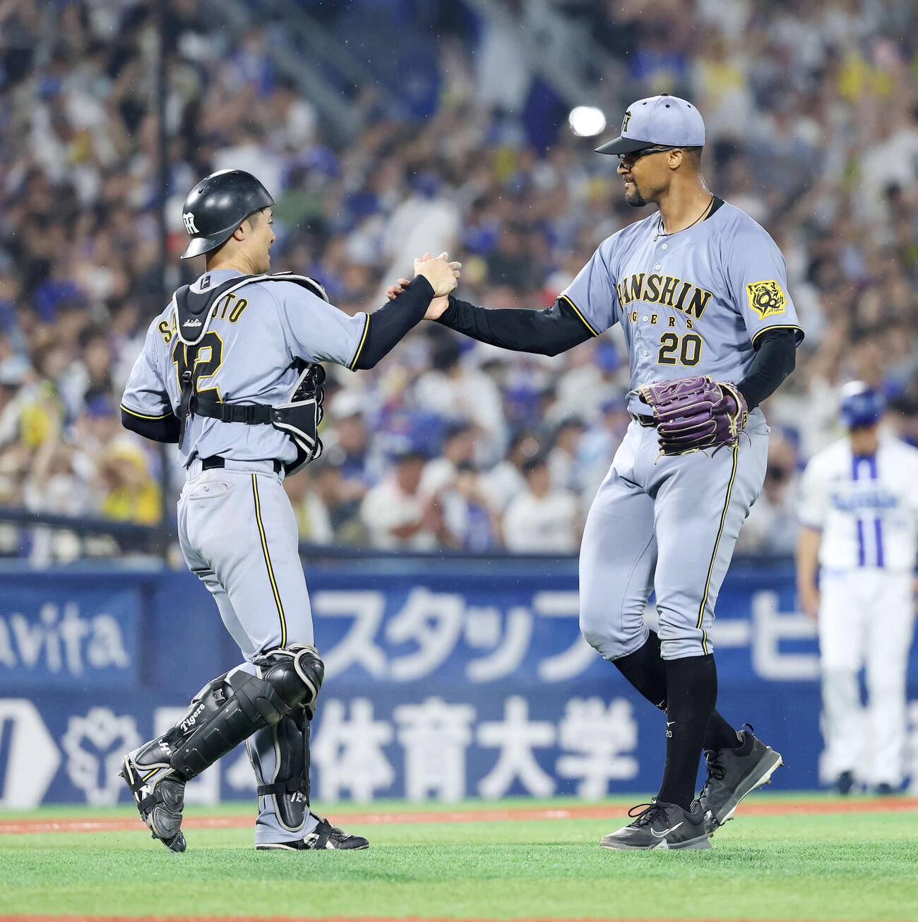 2025年7月、DeNA対阪神で勝利しタッチする阪神坂本（左）デュプランティエ