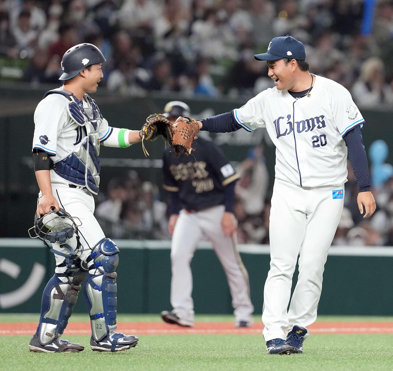 9回を無失点で抑え初セーブを挙げた岩城は、捕手古賀と笑顔でタッチする（2026年3月31日撮影）