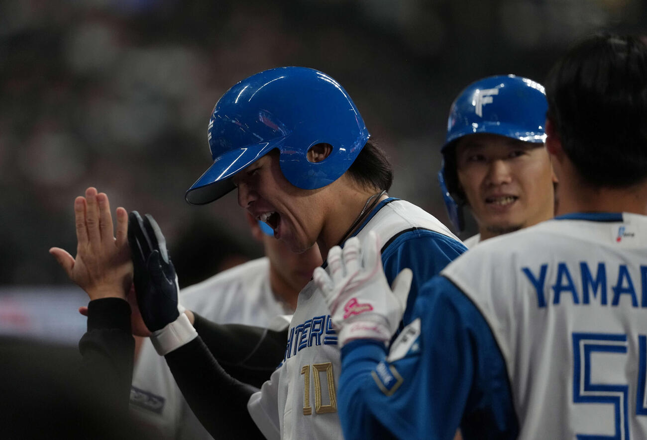 日本ハム対ロッテ　6回裏日本ハム1死一塁、2点本塁打を放ち生還する清水。右は西川（撮影・井上学）