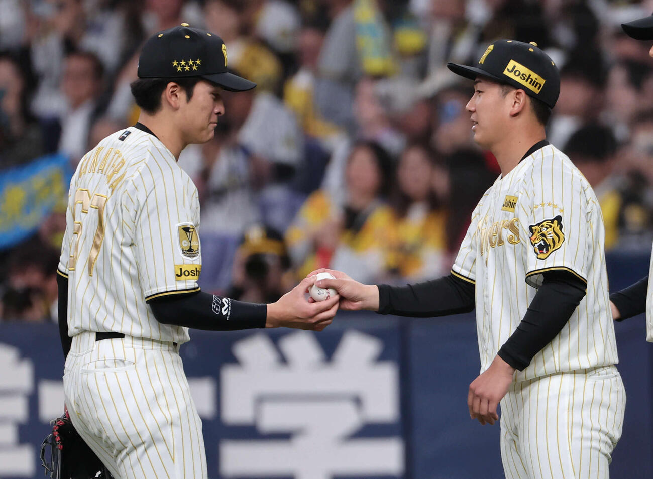 阪神対DeNA　今季初勝利の阪神伊原（右）は最後の打球を処理した高寺からウイニングボールを受け取る（撮影・西尾就之）