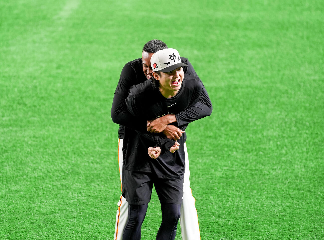 マルティネス（後ろ）に強く抱きつかれ痛がる巨人田中瑛（撮影・増田悦実）
