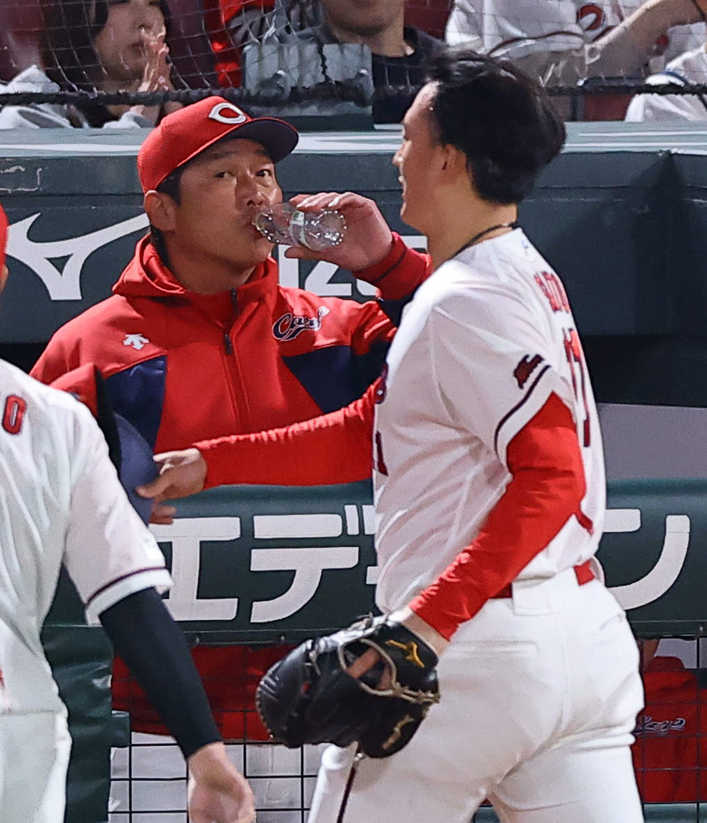 広島対阪神　7回、ベンチで水を飲む新井監督。右は追加点を許した斉藤（撮影・上田博志）