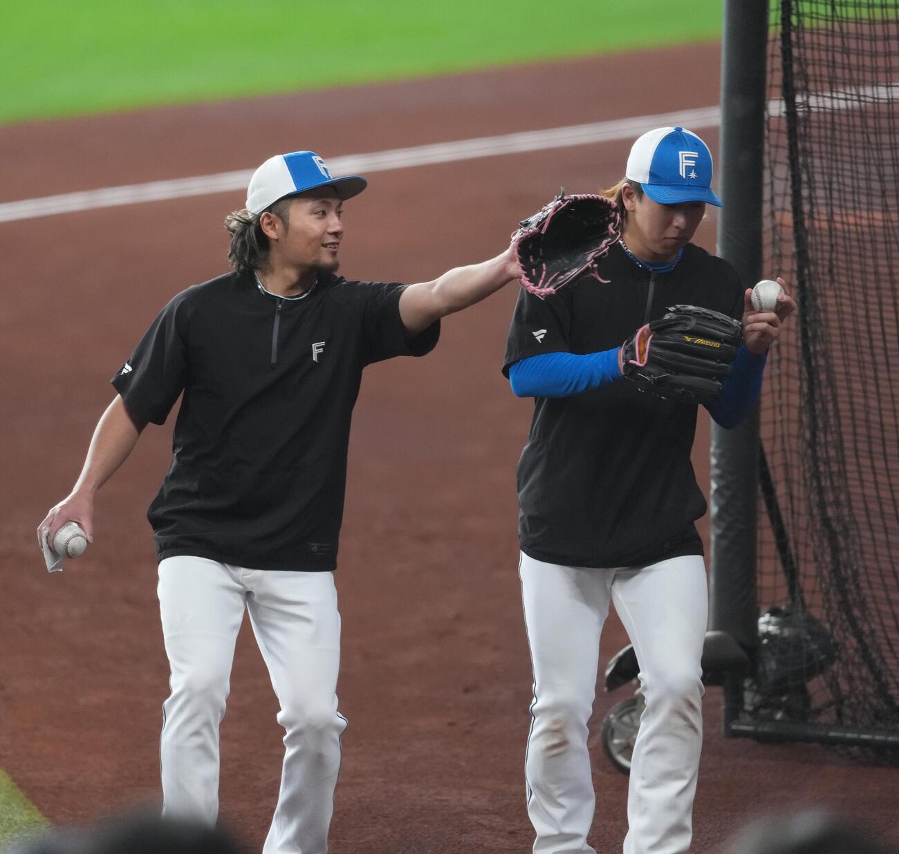 日本ハム対オリックス　試合前の練習を終え引き揚げる日本ハム伊藤（左）と細野（撮影・井上学）