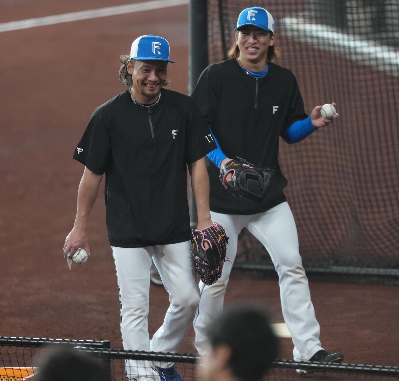 日本ハム対オリックス　試合前の練習を終え引き揚げる日本ハム伊藤（左）と細野（撮影・井上学）