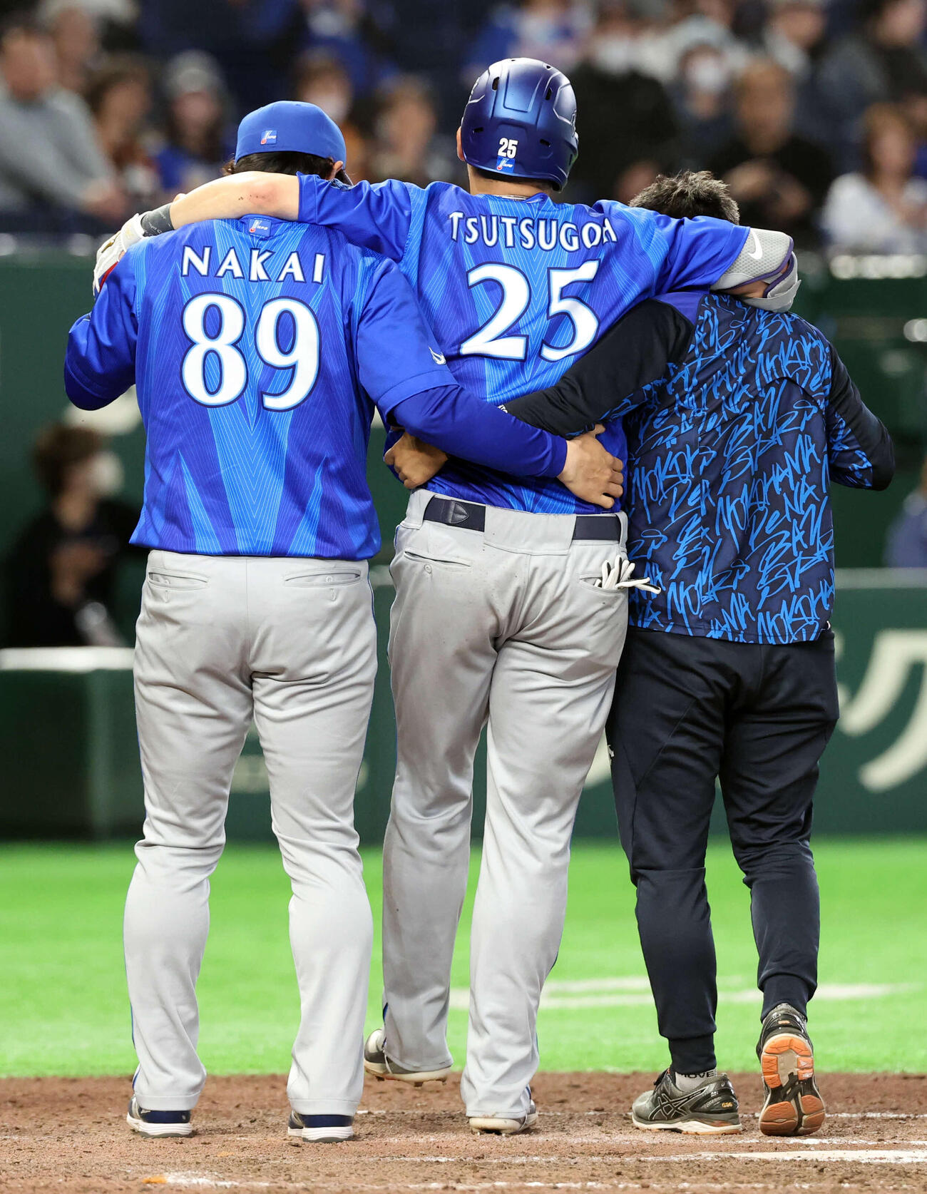 巨人対DeNA 7回表DeNA1一塁、筒香は左ひざに死球を受け、抱えられながらベンチに下がる（撮影・浅見桂子）