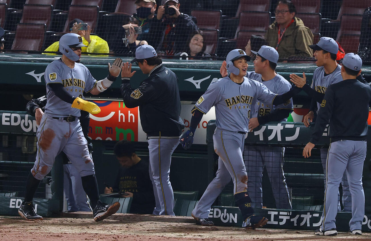 広島対阪神　10回表阪神1死一塁、勝ち越し2点本塁打を放った木浪（中央）はナインの出迎えを受ける（撮影・上田博志）