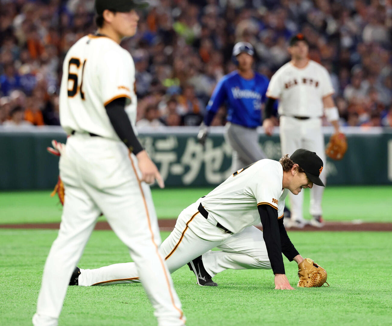 4月4日の巨人対DeNA 4回表DeNA無死一、二塁、入江の送りバントを捕球し、送球時に足を痛め倒れ込むハワード（（撮影・浅見桂子）