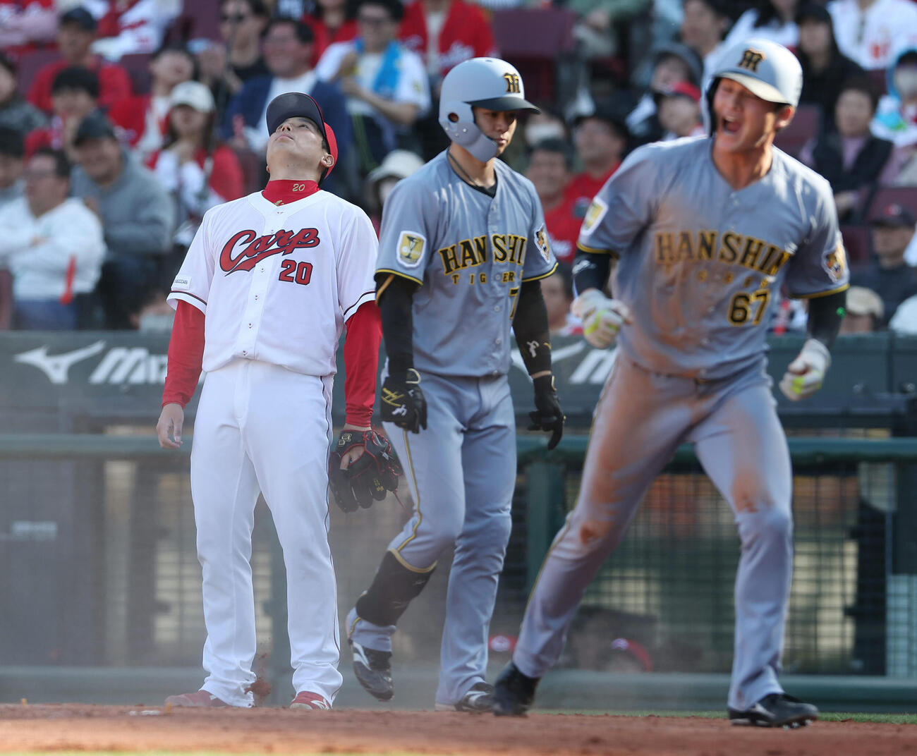 広島対阪神　8回表阪神1死一、三塁、近本に同点犠飛を許した栗林（左）。右は生還した高寺、中央は中野（撮影・前田充）