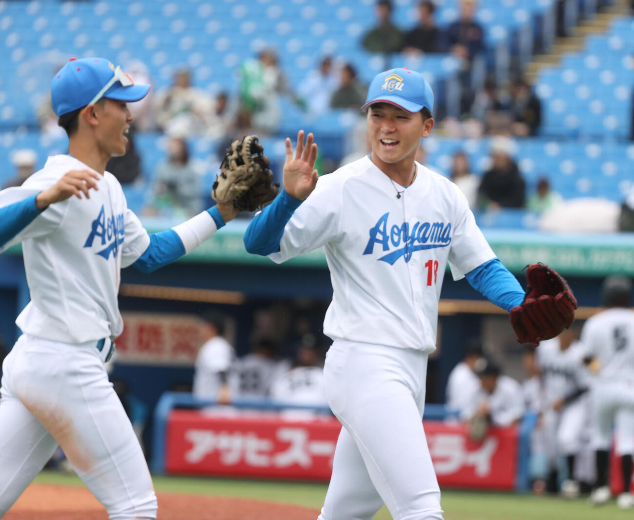 青学大対亜大　4回のピンチを抑えた青学大・鈴木（右）はナインとハイタッチする（撮影・柴田隆二）