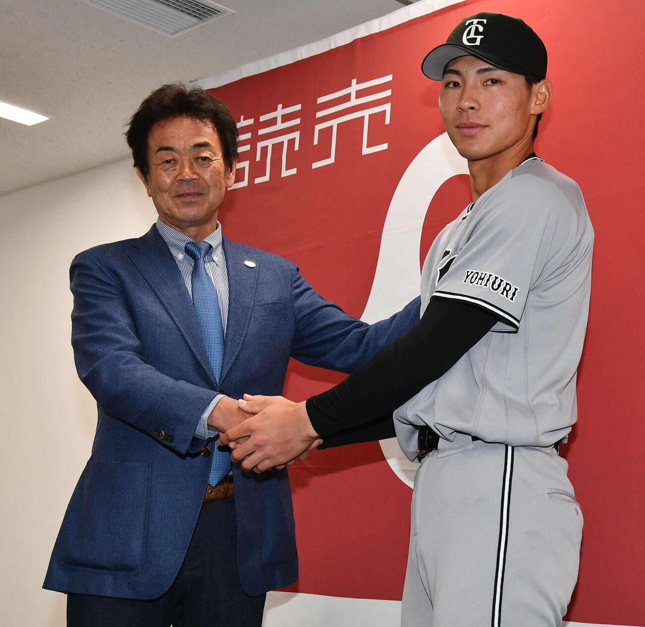 支配下登録会見で水野編成本部長（左）と握手を交わす巨人平山（撮影・岩下翔太）