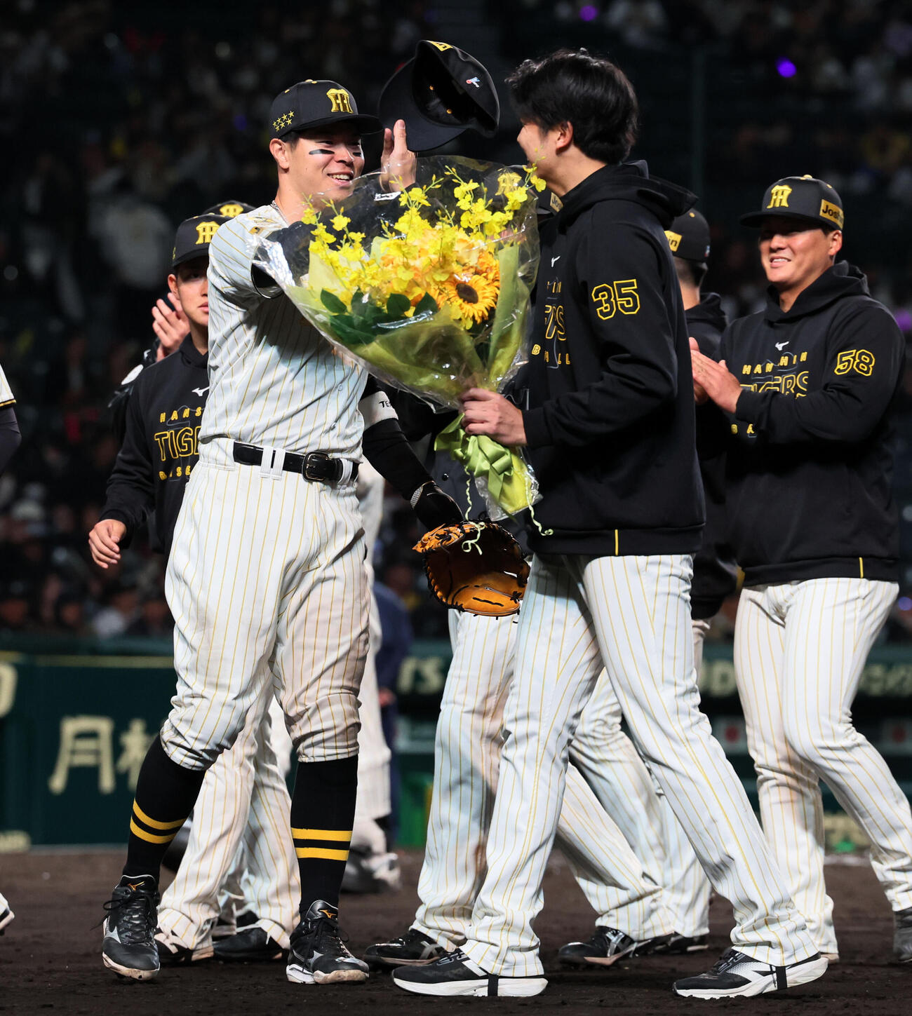 阪神対ヤクルト　阪神才木はリーグタイ記録の1試合奪三振「16」を記録し佐藤（左）とタッチする（撮影・加藤哉）