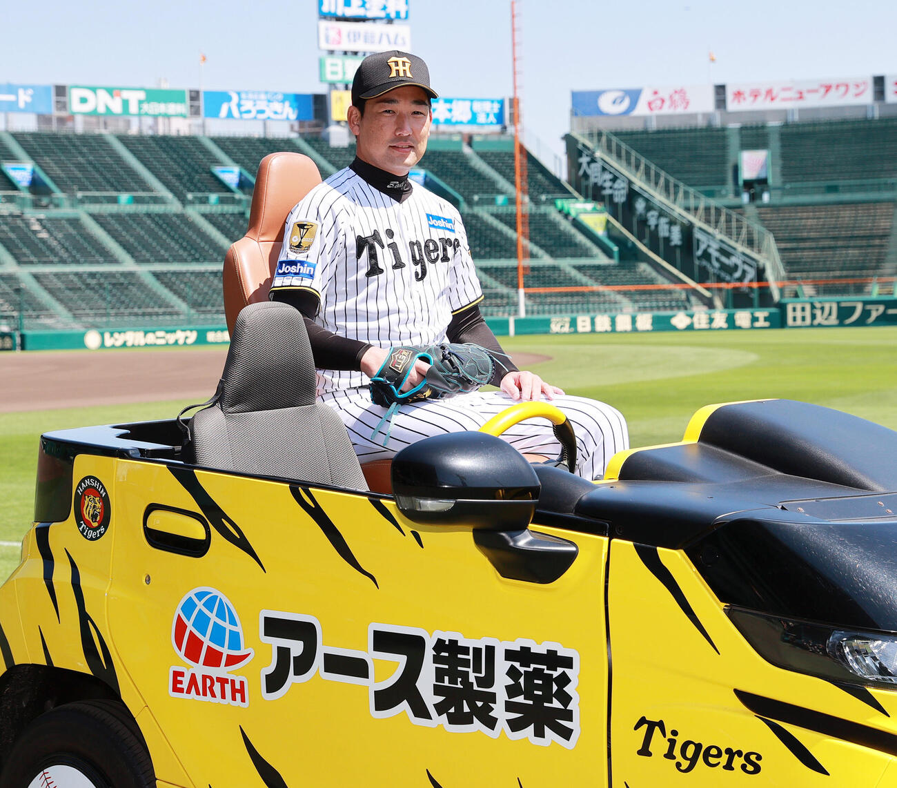 新しくなった甲子園球場のリリーフカーに搭乗し、笑顔を見せる阪神岩崎（撮影・上山淳一）