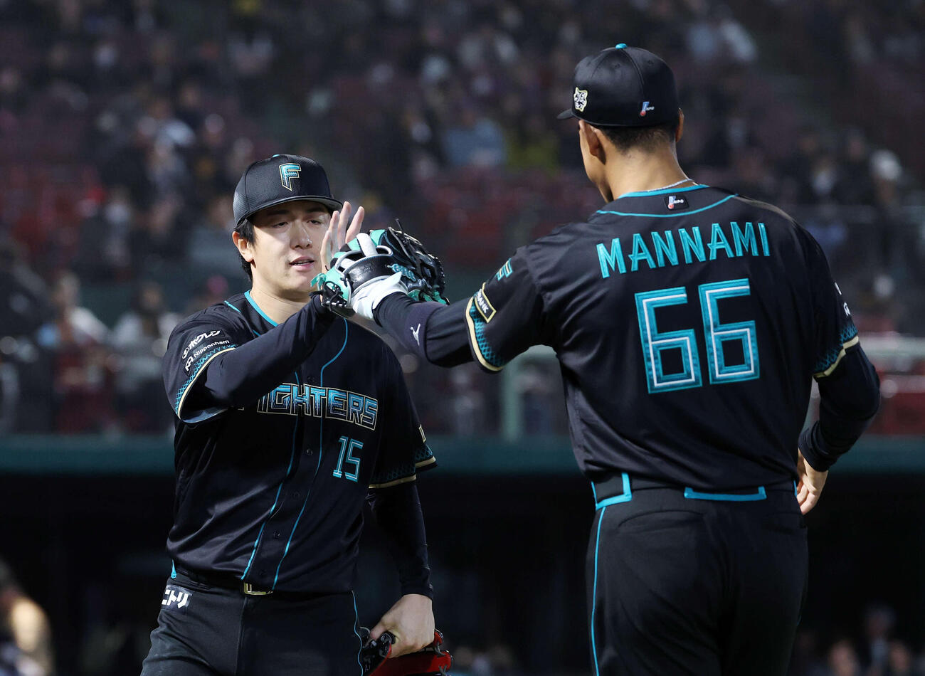 楽天対日本ハム　8回裏、楽天の攻撃を抑え日本ハム万波（右）とタッチする北山（撮影・鈴木正人）　