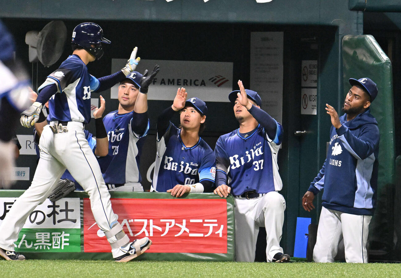 ソフトバンク対西武　1回表西武2死、小島（左）は先制本塁打を放ちナインとタッチを交わす（撮影・林敢治）