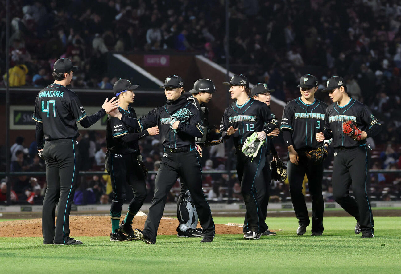 楽天対日本ハム　勝利しタッチを交わす日本ハムの選手たち（撮影・鈴木正人）　