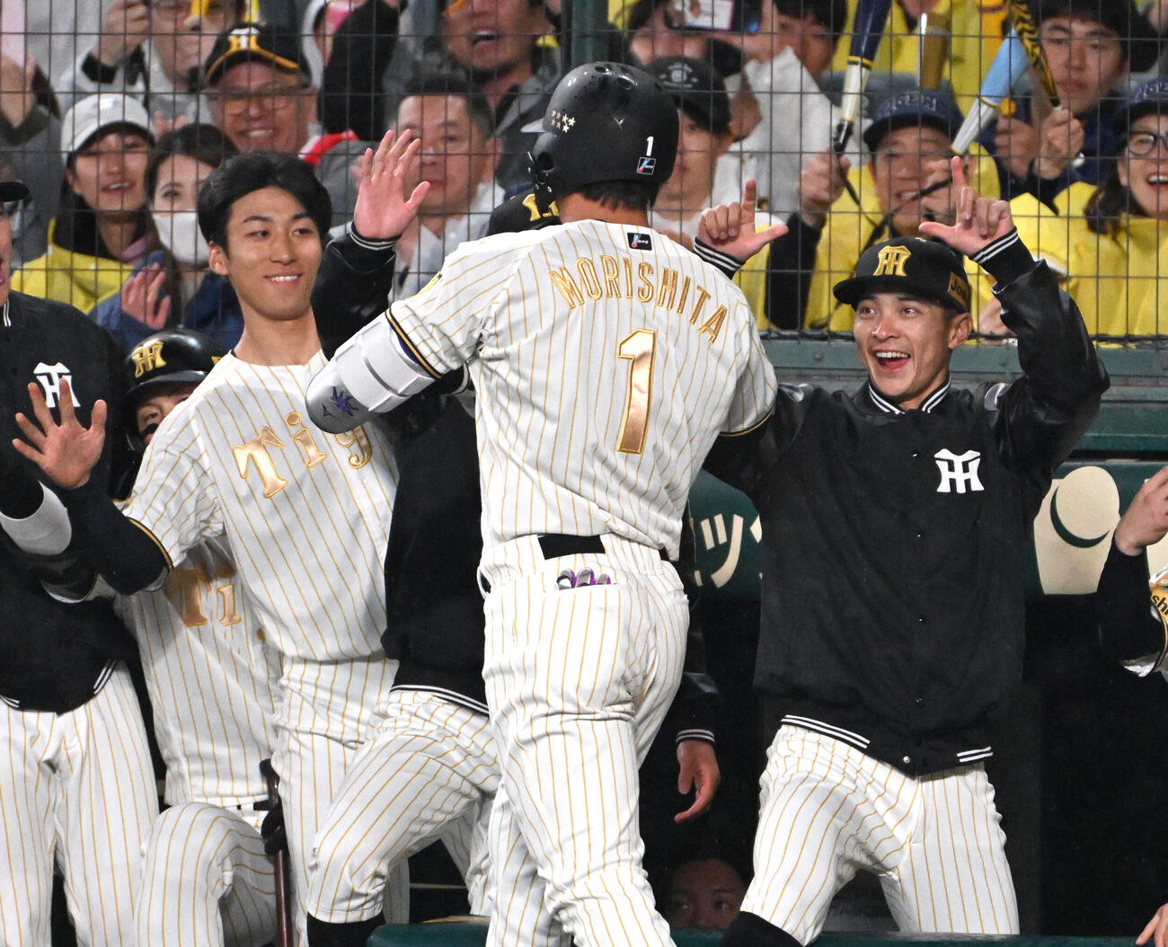 阪神対ヤクルト　4回裏阪神無死　森下（背中）は先制本塁打を放ちナインに迎えられる。左は茨木（撮影・石井愛子）