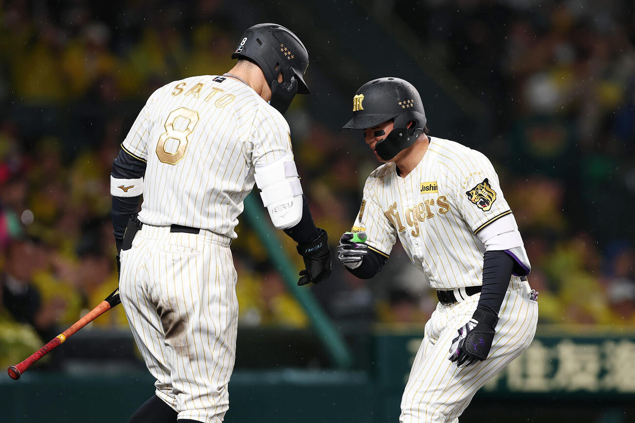 阪神対ヤクルト　4回裏阪神無死、左越え本塁打を放ち佐藤（左）に迎えられる森下（撮影・前田充）