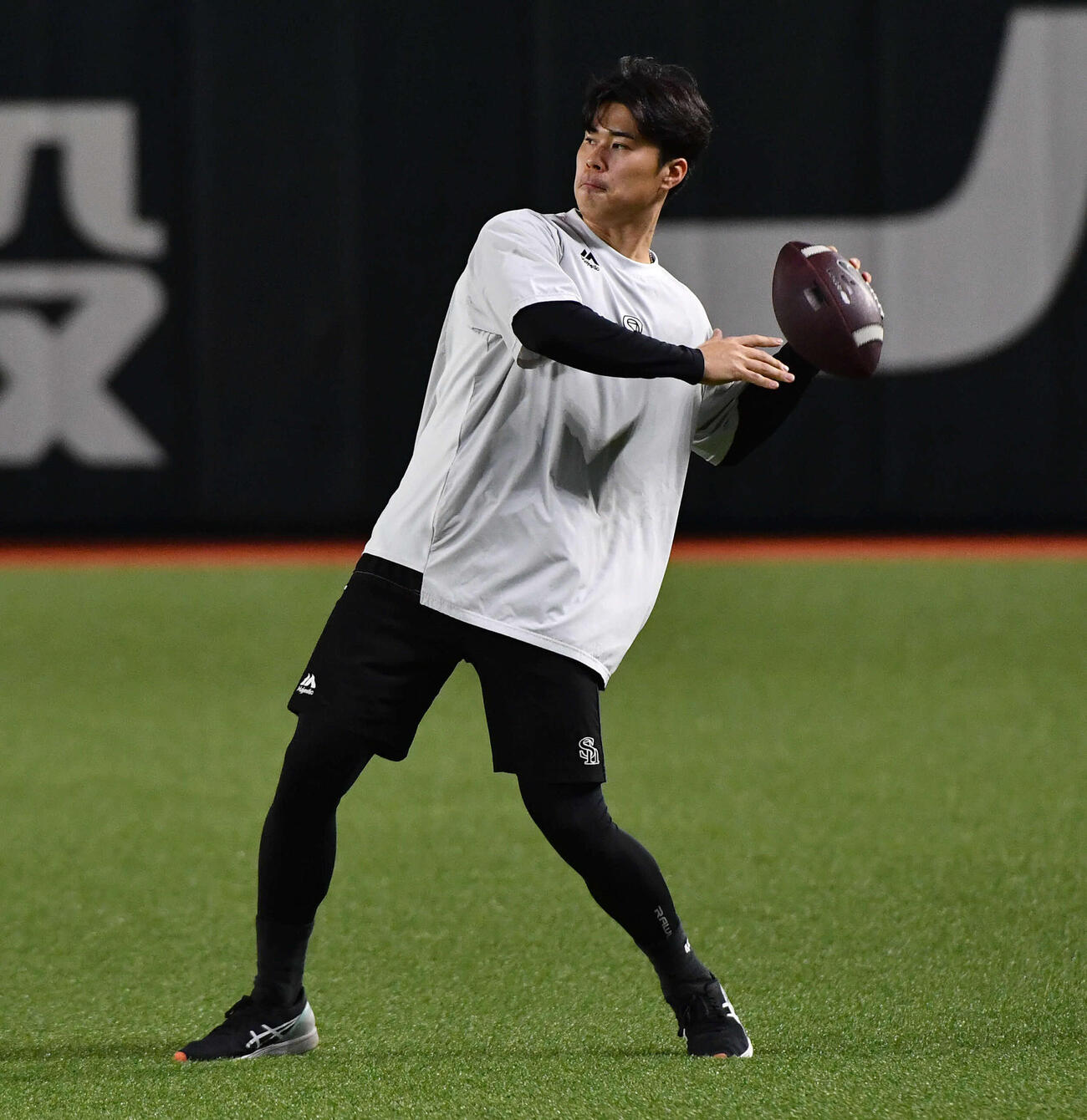 アメフトボールを投げるソフトバンク松本晴（撮影・岩下翔太）