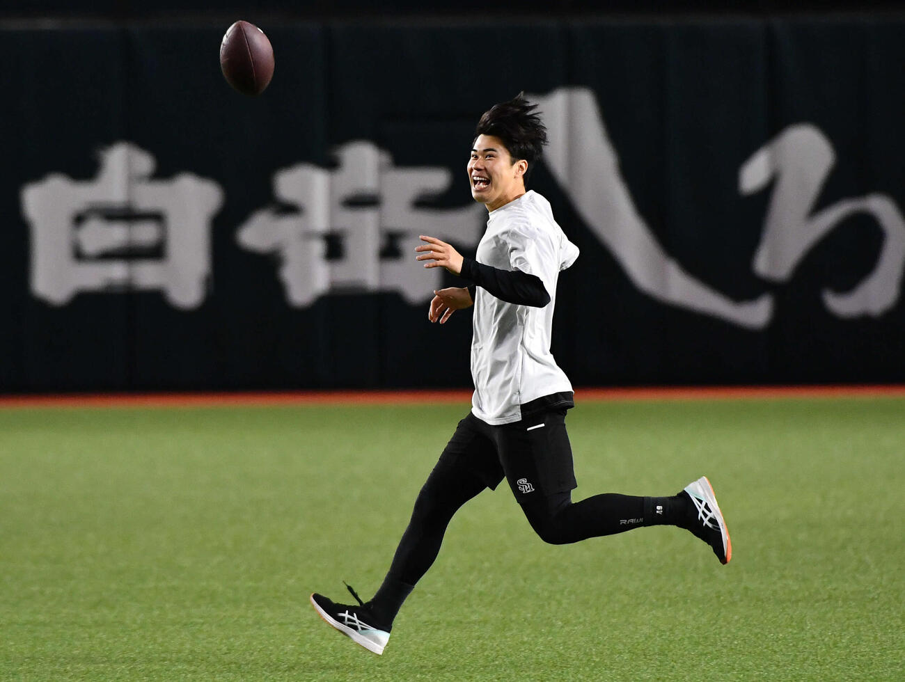 笑顔でアメフトボールを追いかけるソフトバンク松本晴（撮影・岩下翔太）