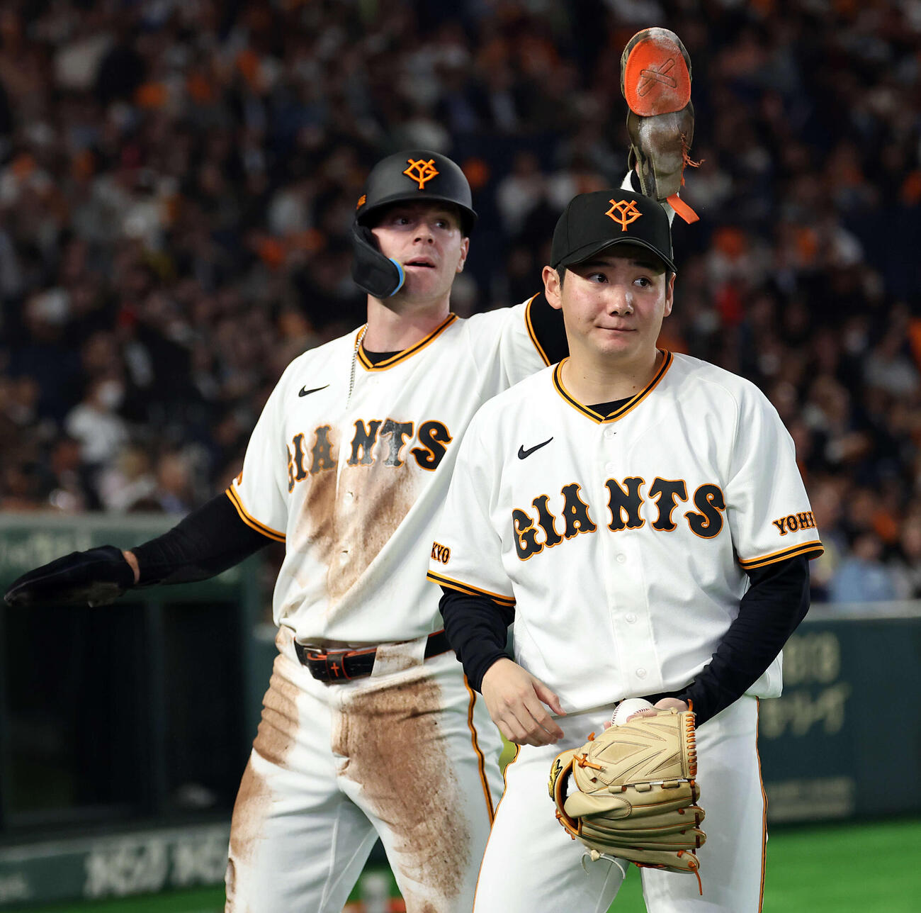 巨人対ヤクルト　2回裏巨人1死一塁、増田陸の先制適時二塁打で生還したキャベッジ（奥）を迎えた竹丸は口元を緩める（撮影・浅見桂子）