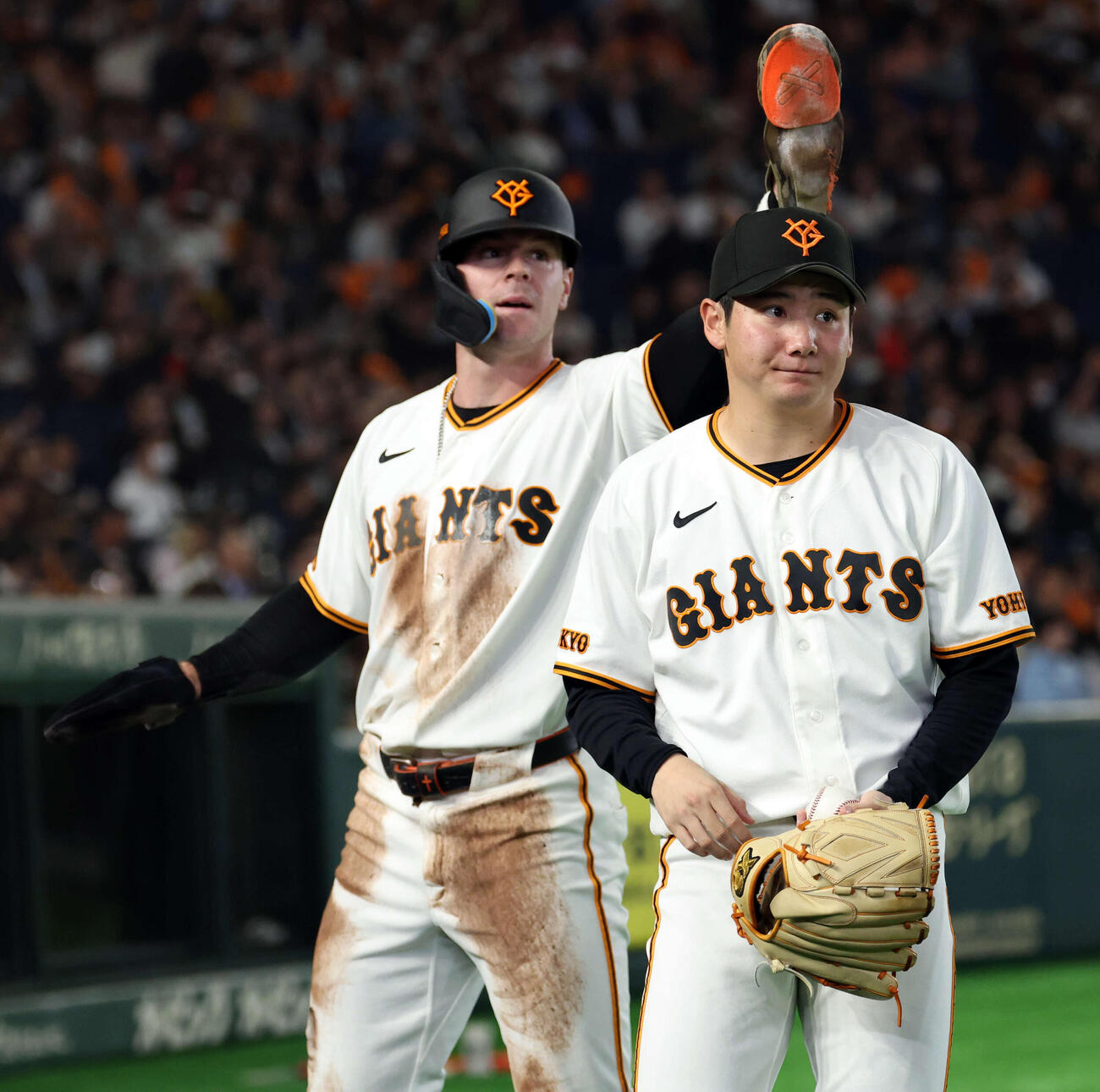 巨人対ヤクルト　2回裏巨人1死一塁、増田陸の先制適時二塁打で生還したキャベッジ（奥）を迎えた竹丸は口元を緩める（撮影・浅見桂子）