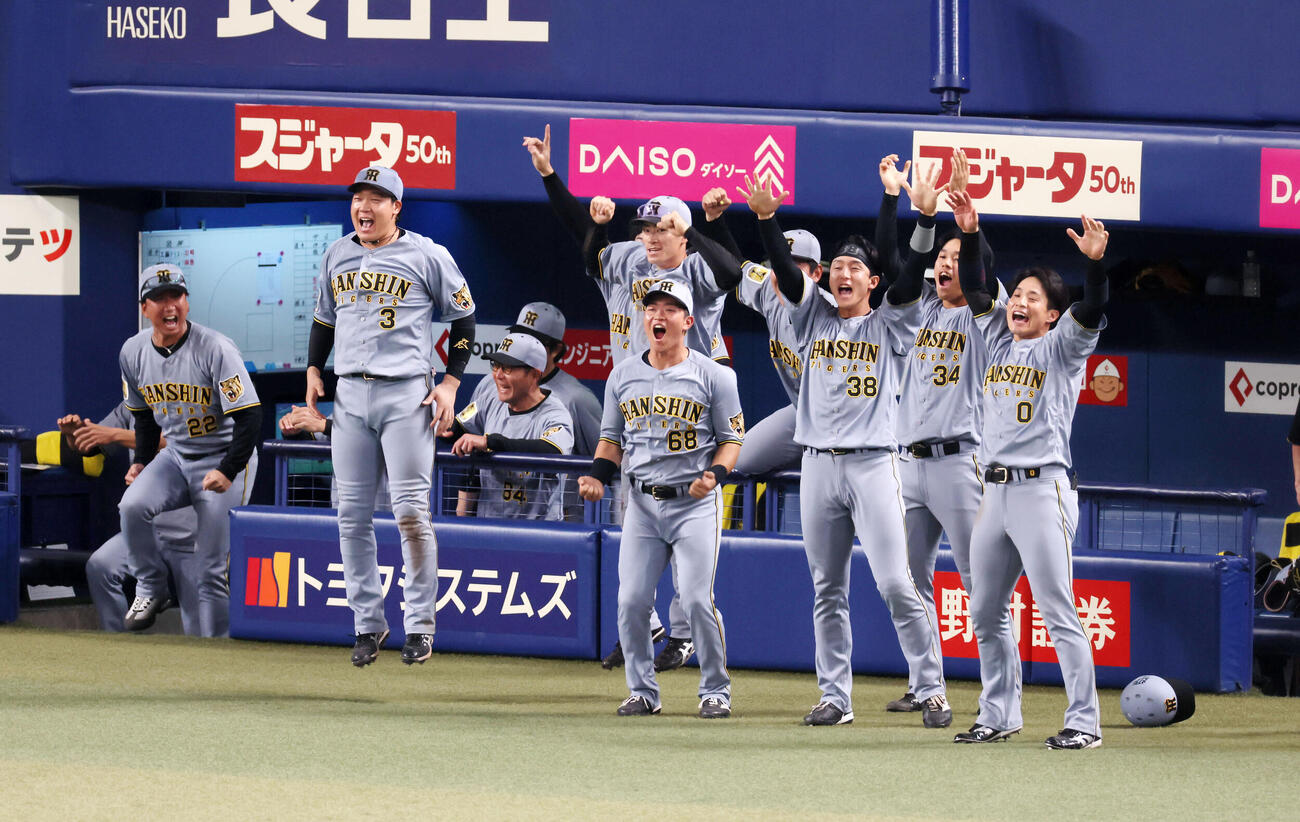 中日対阪神　9回表阪神2死一、三塁、代打前川の右越え適時二塁打にベンチ前で喜ぶナイン。左端は藤川監督（撮影・加藤哉）