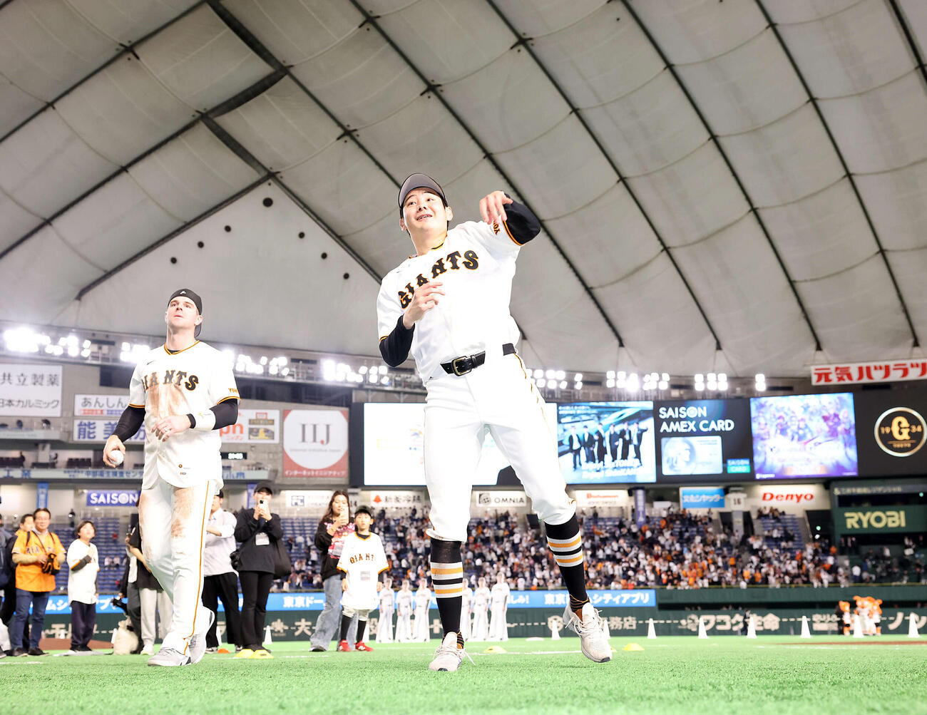 巨人対ヤクルト　2勝目を挙げた巨人竹丸（中央）は笑顔でスタンドにボールを投げ入れる。後方はキャベッジ（撮影・浅見桂子）