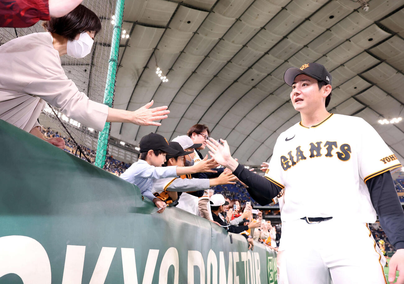 巨人対ヤクルト　2勝目を挙げた巨人竹丸（右）はファンとハイタッチ（撮影・浅見桂子）
