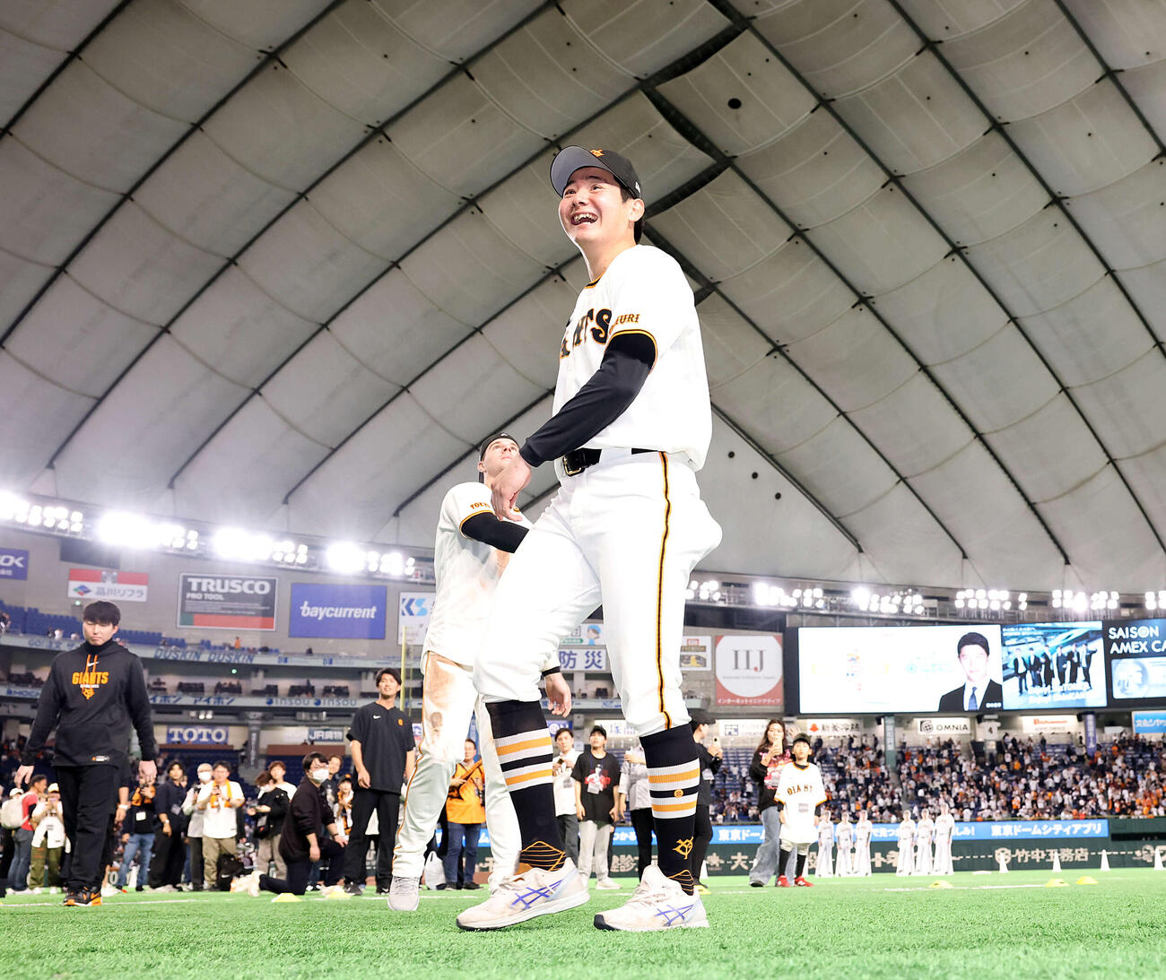 巨人対ヤクルト　2勝目を挙げた巨人竹丸（中央）はスタンドにボールを投げ入れ笑顔。後方はキャベッジ（撮影・浅見桂子）