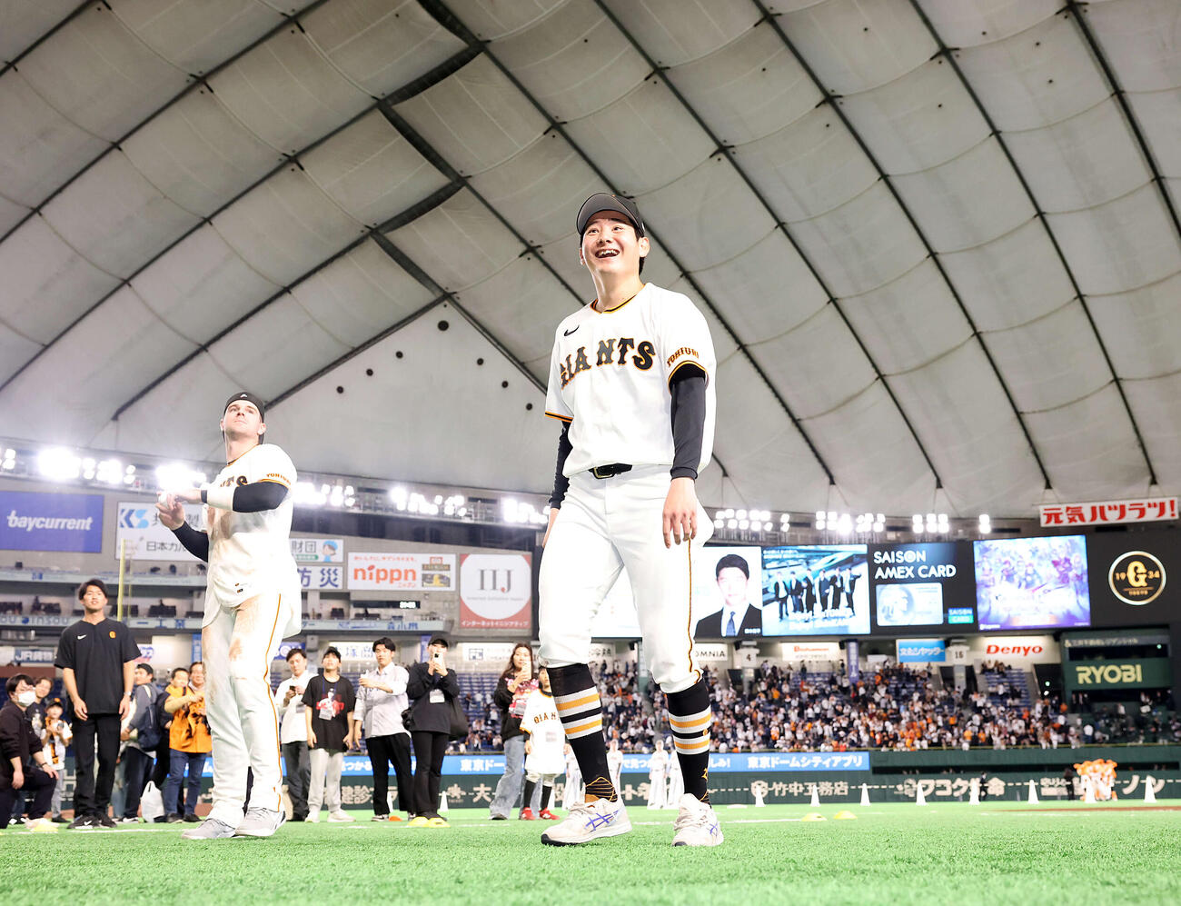 巨人対ヤクルト　2勝目を挙げた巨人竹丸（中央）はスタンドにボールを投げ入れ笑顔。後方はキャベッジ（撮影・浅見桂子）