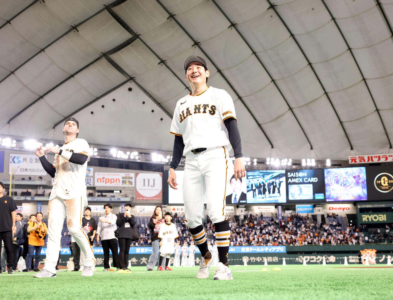 巨人対ヤクルト　2勝目を挙げた巨人竹丸（中央）は笑顔でスタンドにボールを投げ入れる。後方はキャベッジ（撮影・浅見桂子）