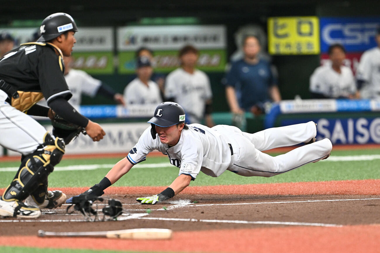 西武対ロッテ　1回裏西武1死一、二塁、渡部の先制適時打で生還する二塁走者源田（右）。捕手松川（撮影・滝沢徹郎）