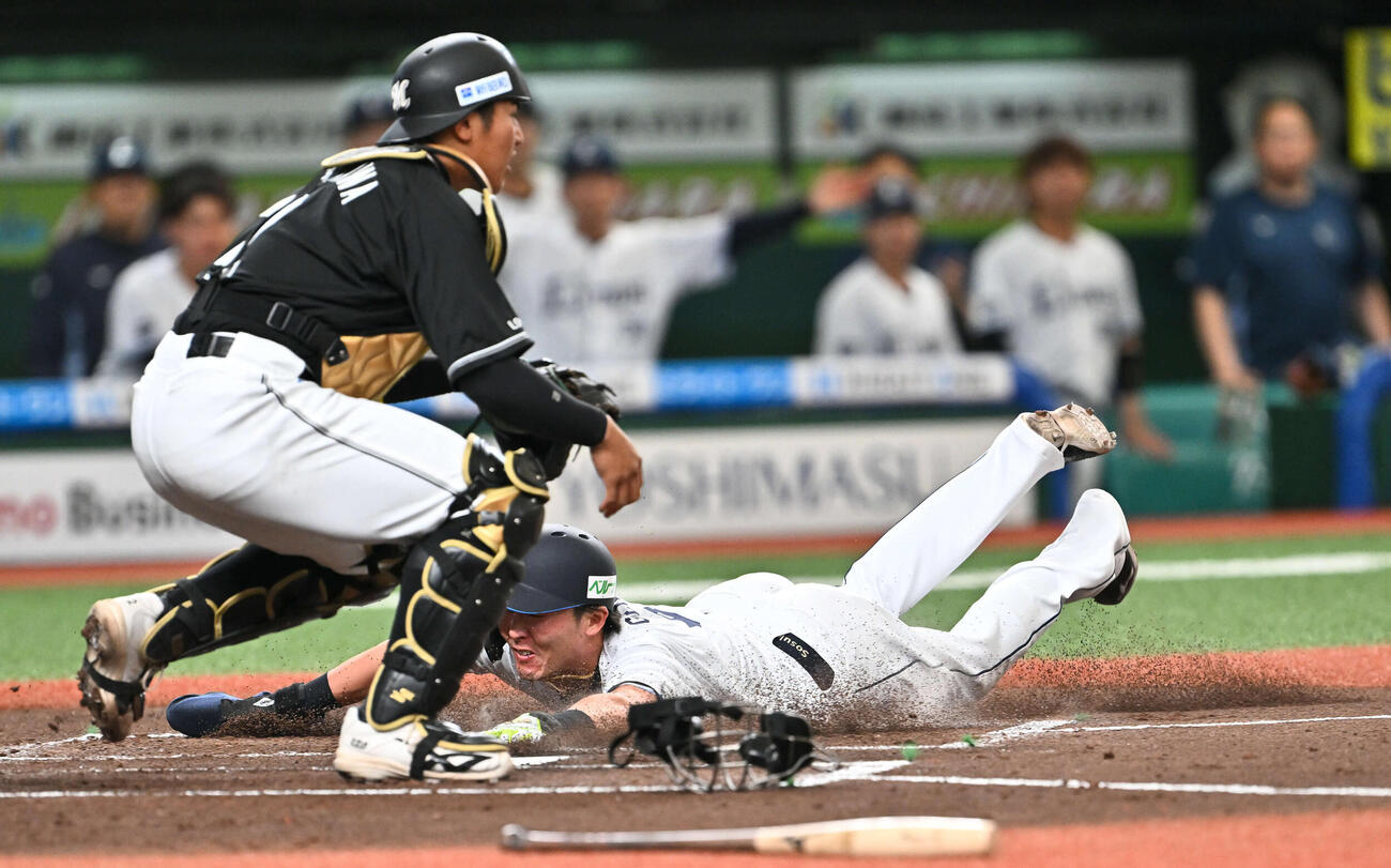 西武対ロッテ　1回裏西武1死一、二塁、渡部の先制適時打で生還する二塁走者源田（右）。捕手松川（撮影・滝沢徹郎）