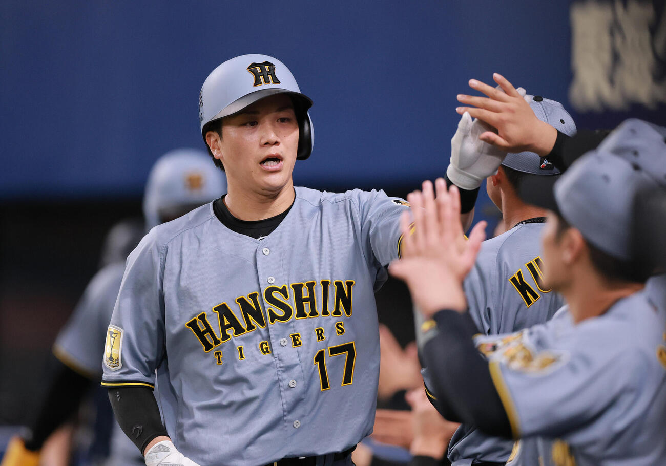 中日対阪神　4回表阪神1死満塁、伏見（左）は中犠飛を放ち祝福を受ける（撮影・上山淳一）