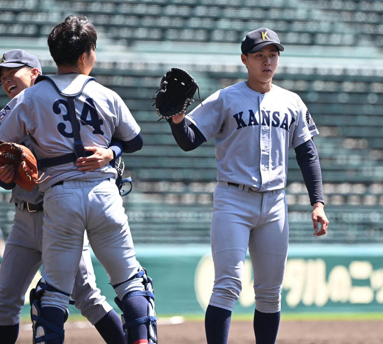 関学大対関大　関学大を1安打完封した関大米沢（右）はナインとタッチ（撮影・和賀正仁）