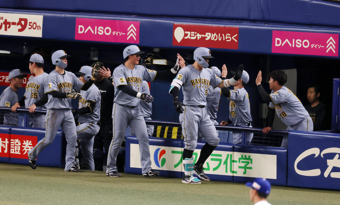 中日対阪神　7回表阪神1死一、二塁、佐藤は右中間越え3点本塁打を放ちベンチの伊原（右）とタッチする。左端は生還した二走中野、中央は一走森下（撮影・加藤哉）