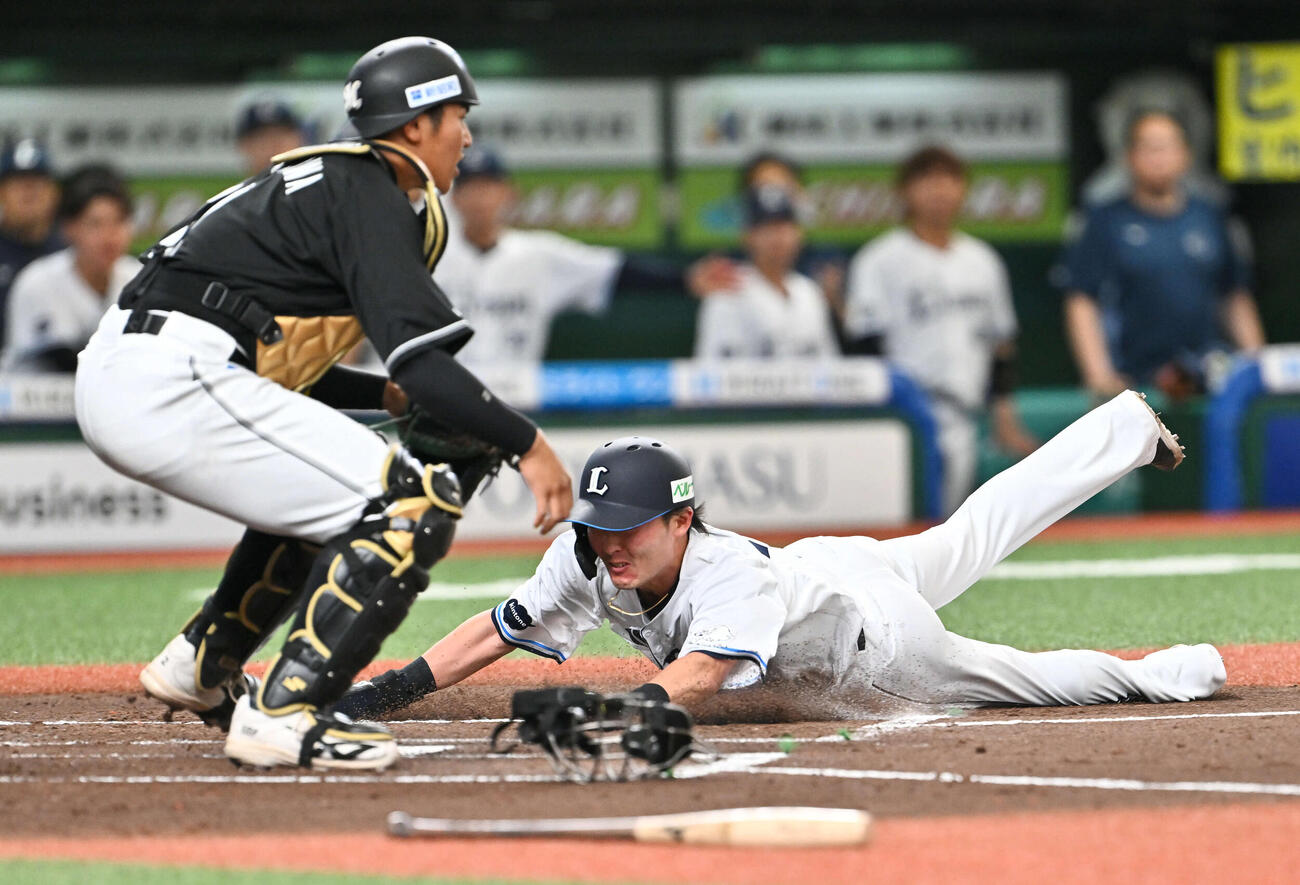 西武対ロッテ　1回裏西武1死一、二塁、渡部の先制適時打で生還する二塁走者源田（右）。捕手松川（撮影・滝沢徹郎）
