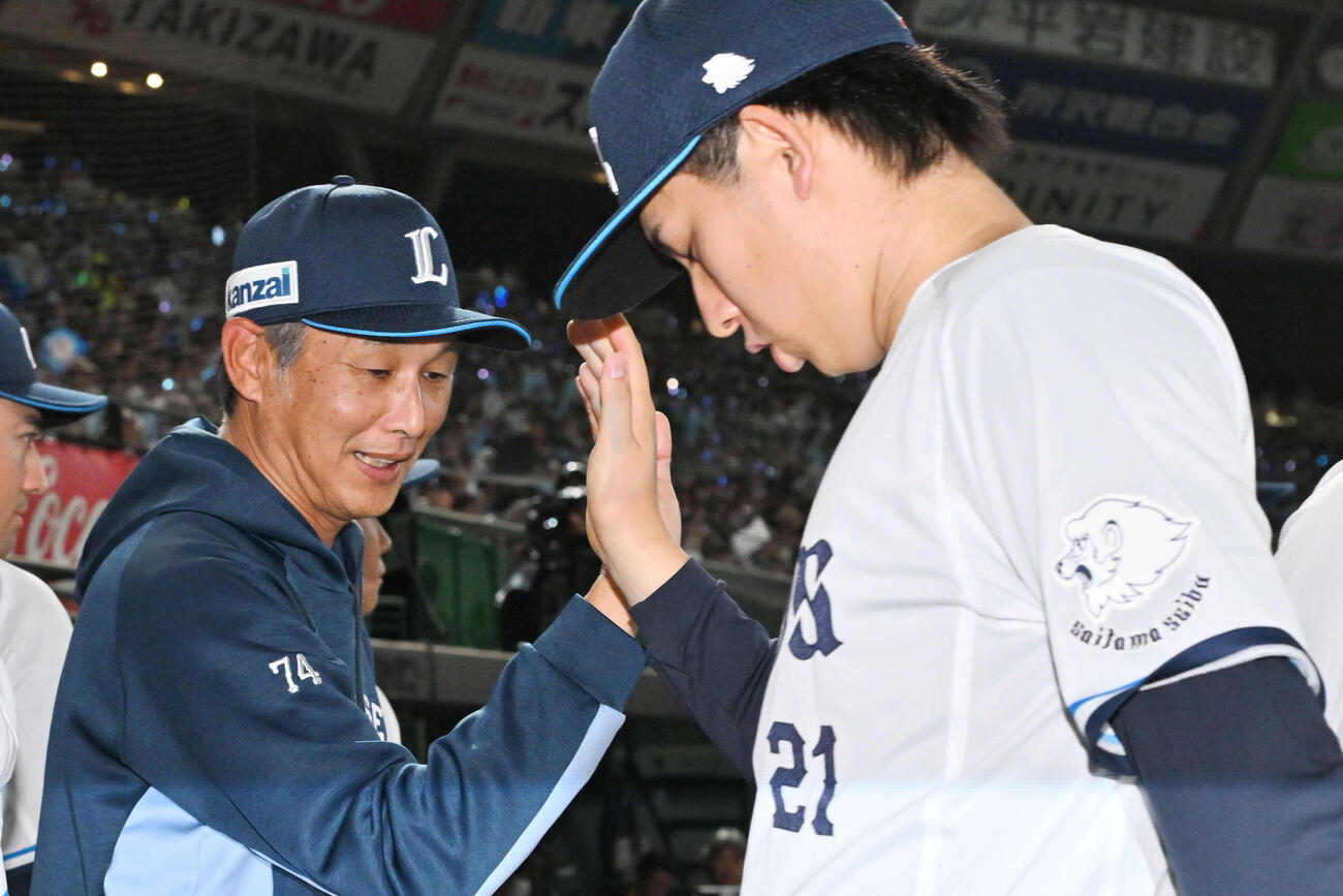 西武対ロッテ　試合後、西武西口監督（左）は武内とタッチを交わす（撮影・滝沢徹郎）